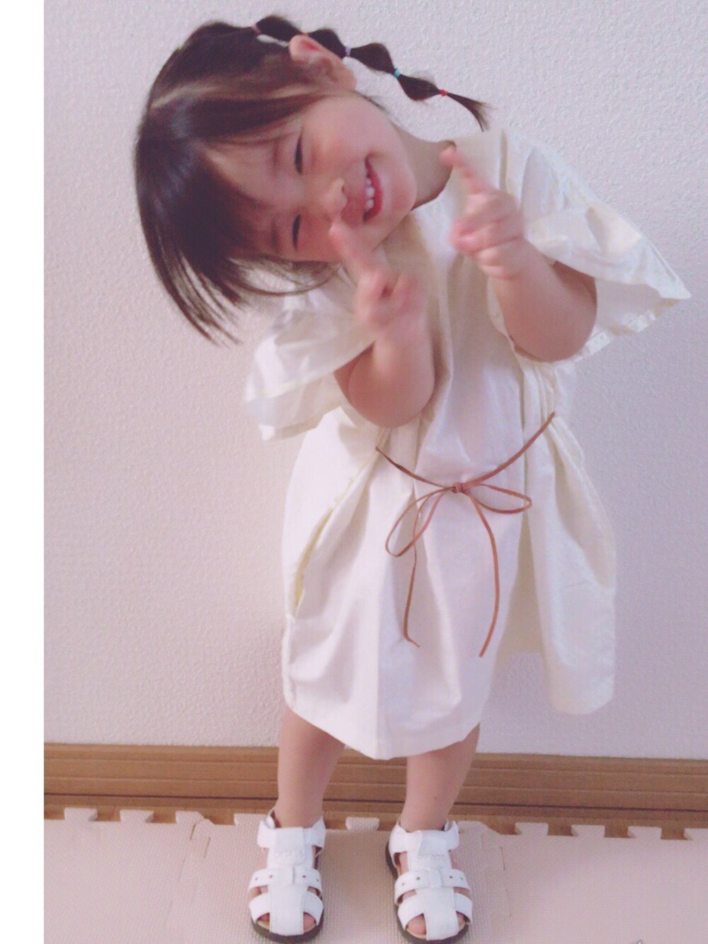 ホワイト系のワンピース、ホワイト系のサンダルを着用したキッズの春コーディネートの1枚目の写真