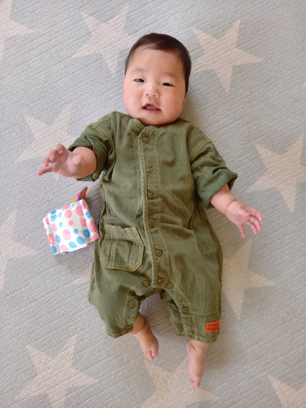 グリーン系のロンパースを着用したキッズの春コーディネートの1枚目の写真