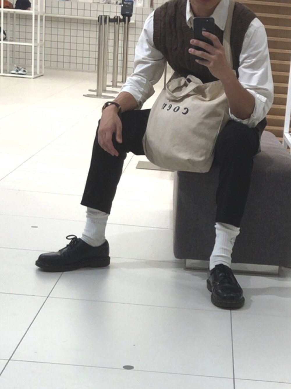 ブラック系のブーツ、ホワイト系のトートバッグ、ブラウン系のニット/セーターを着用したメンズの秋コーディネートの1枚目の写真