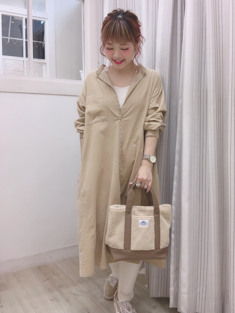 ベージュ系のシャツワンピース、ベージュ系のトートバッグ、ホワイト系のパンツを着用したレディースの冬コーディネートの1枚目の写真