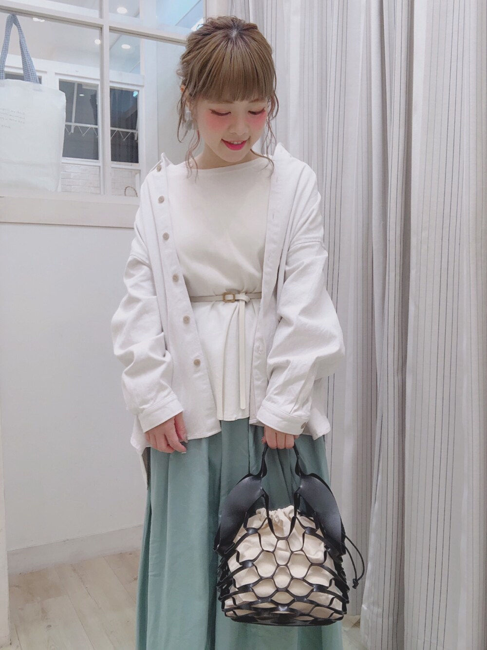 ブルー系のジャケット/アウター、ベージュ系のTシャツ/カットソー、ブラック系のバッグを着用したレディースの春コーディネートの1枚目の写真