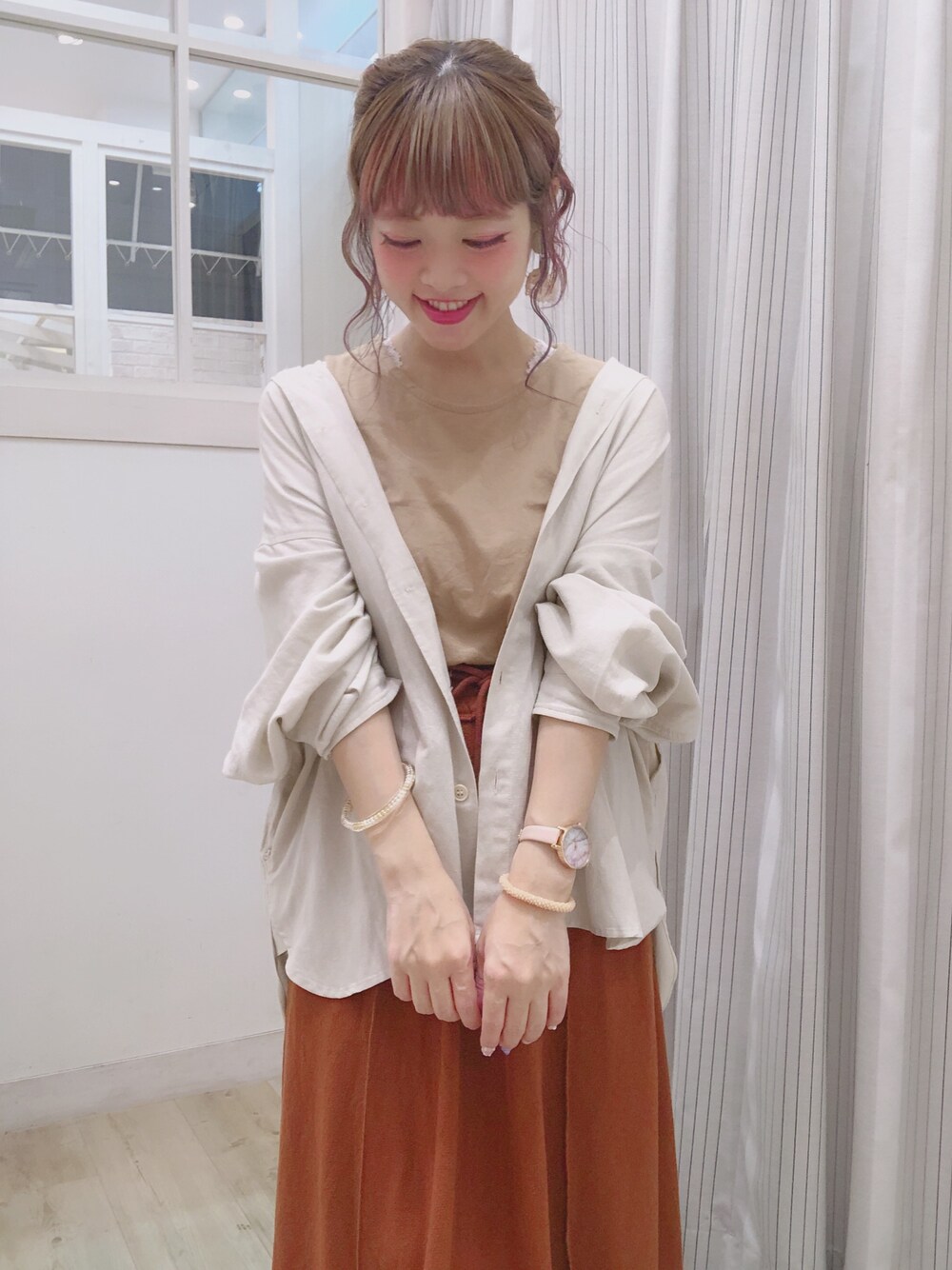 ブラウン系のスカート、ブルー系のトップス、ベージュ系のタンクトップを着用したレディースの夏コーディネートの1枚目の写真