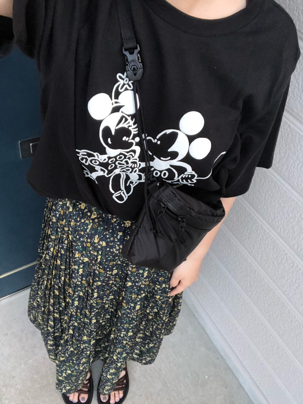 ブラック系のTシャツ/カットソー、ブルー系のスカート、ブラウン系のサンダルを着用したレディースの夏コーディネートの1枚目の写真