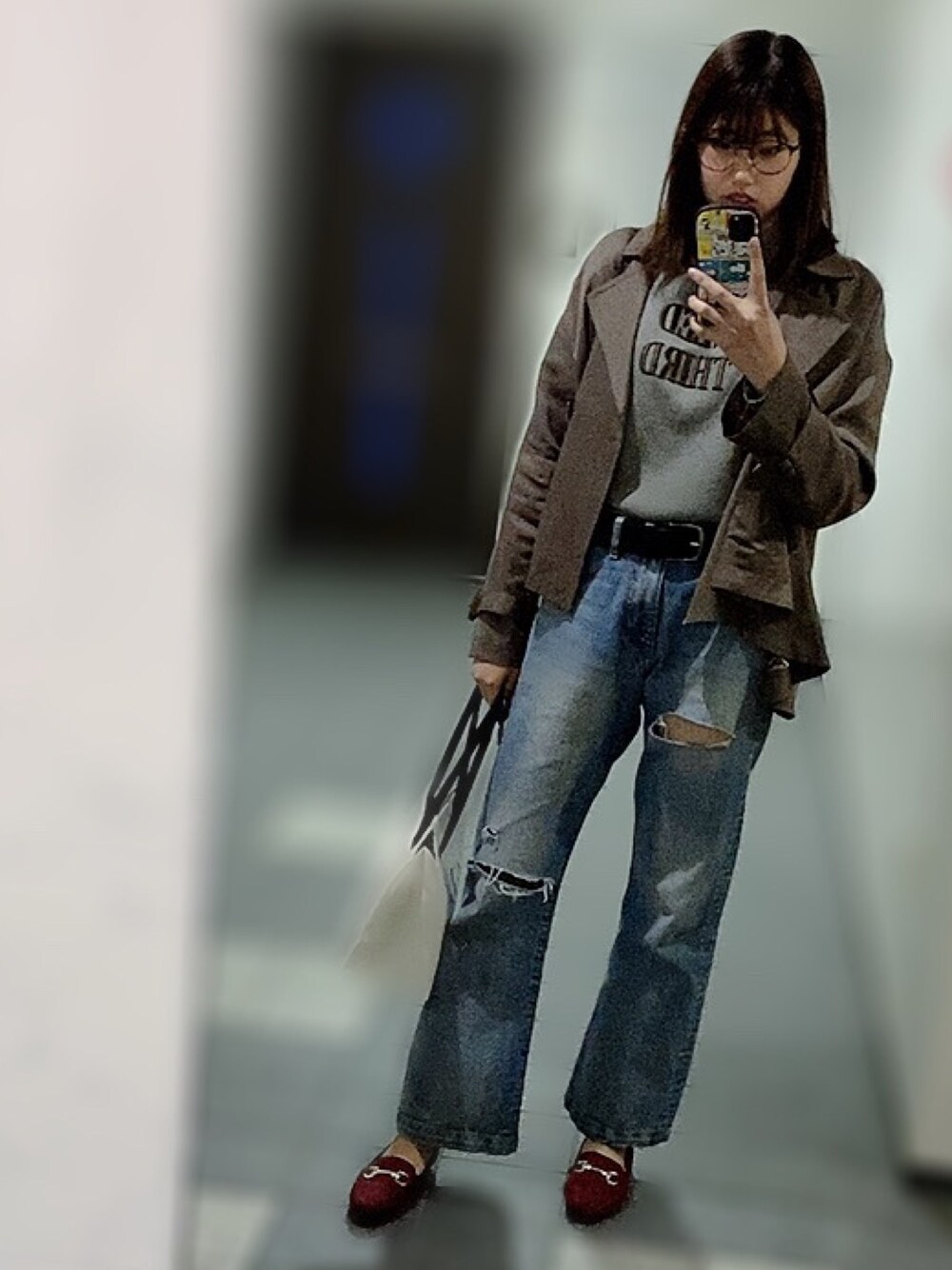 グレー系のニット/セーター、ブルー系のデニムパンツ、レッド系のローファーを着用したレディースの春コーディネートの1枚目の写真