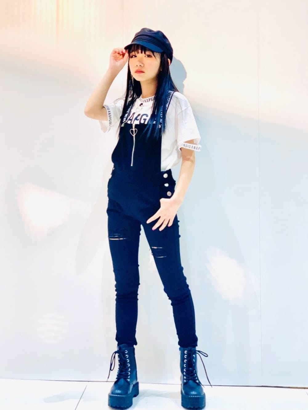 ホワイト系のTシャツ/カットソー、ブラック系のサロペット/オーバーオール、ブラック系のブーツを着用したレディースの春コーディネートの1枚目の写真