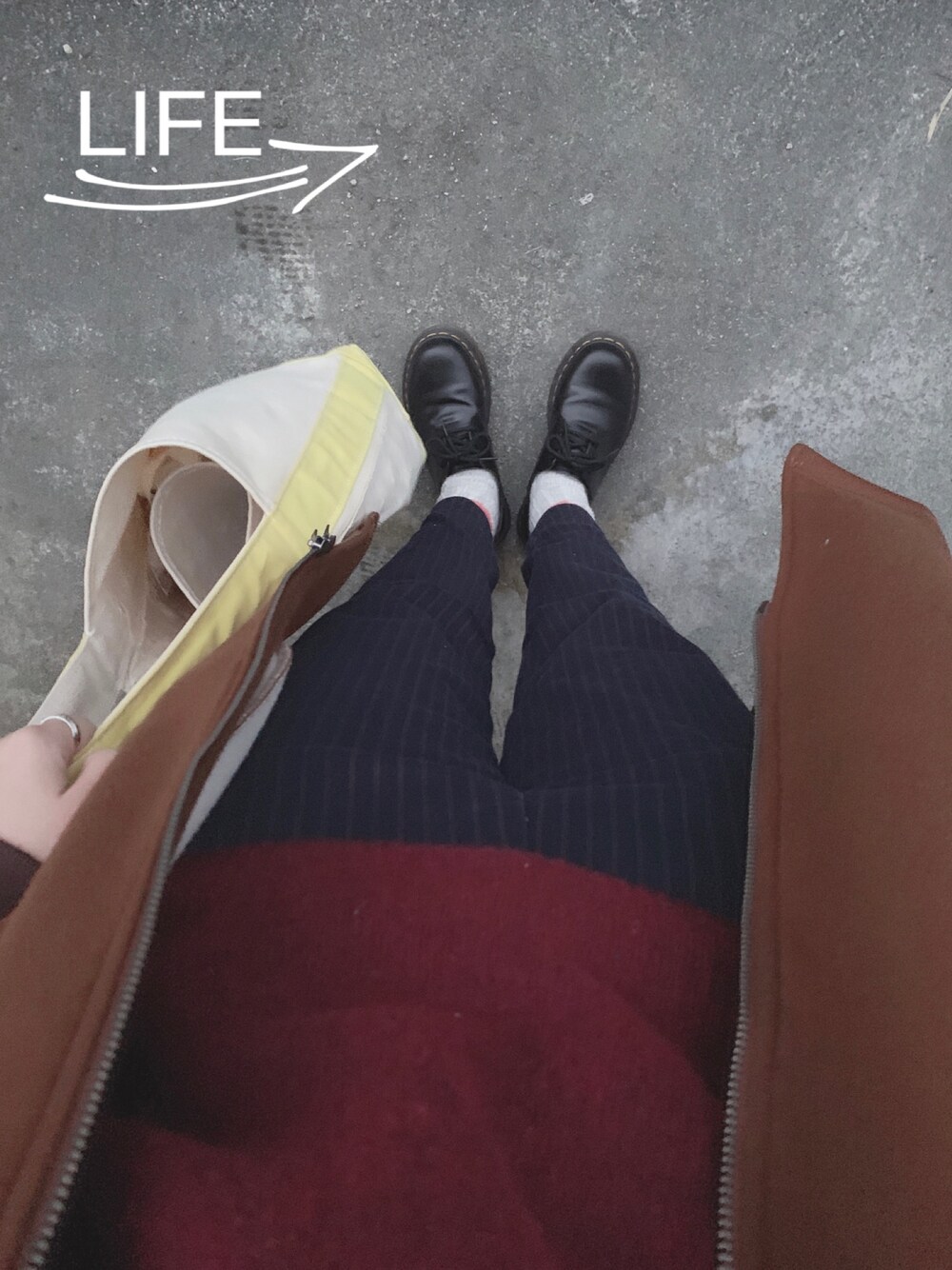 ブラック系のブーツ、イエロー系のトートバッグ、ブルー系のその他パンツを着用したレディースの冬コーディネートの1枚目の写真