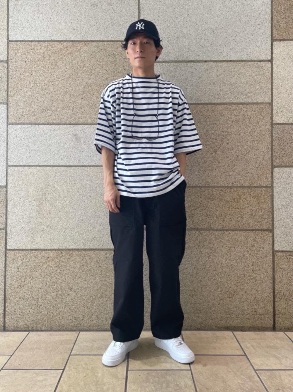 ブルー系のTシャツ/カットソー、ホワイト系のスニーカー、ブラック系のサングラスを着用したメンズの夏コーディネートの1枚目の写真