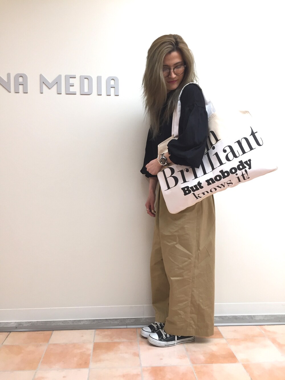 ブラック系のTシャツ/カットソー、ホワイト系のトートバッグ、ブラウン系のその他パンツを着用したレディースの春コーディネートの1枚目の写真