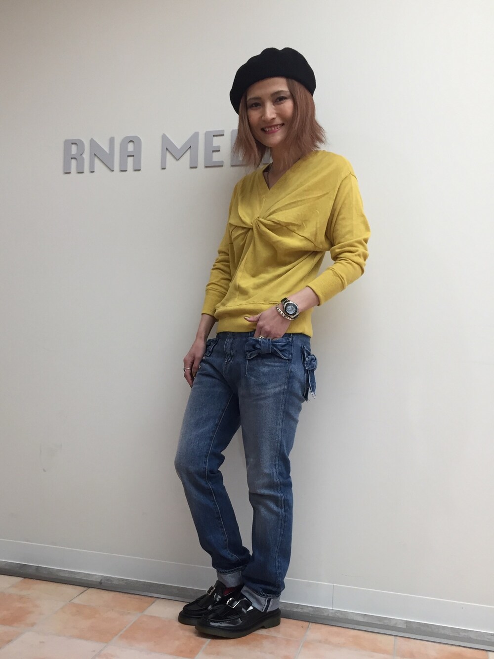 イエロー系のTシャツ/カットソー、ブルー系のデニムパンツ、ブラック系のモカシン/デッキシューズを着用したレディースの冬コーディネートの1枚目の写真