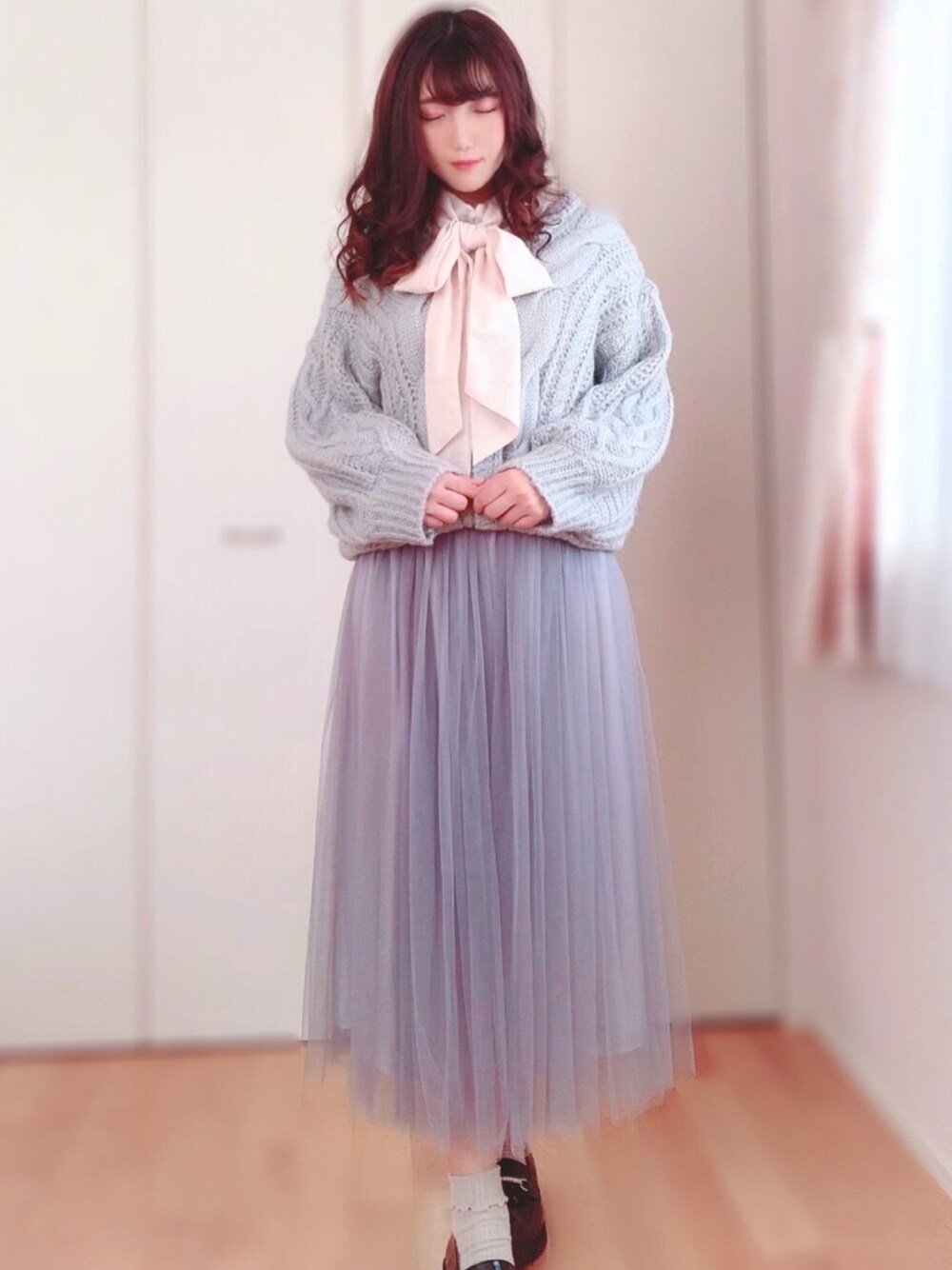 ブルー系のカーディガン/ボレロ、ホワイト系のシャツ/ブラウス、グレー系のスカートを着用したレディースの冬コーディネートの1枚目の写真