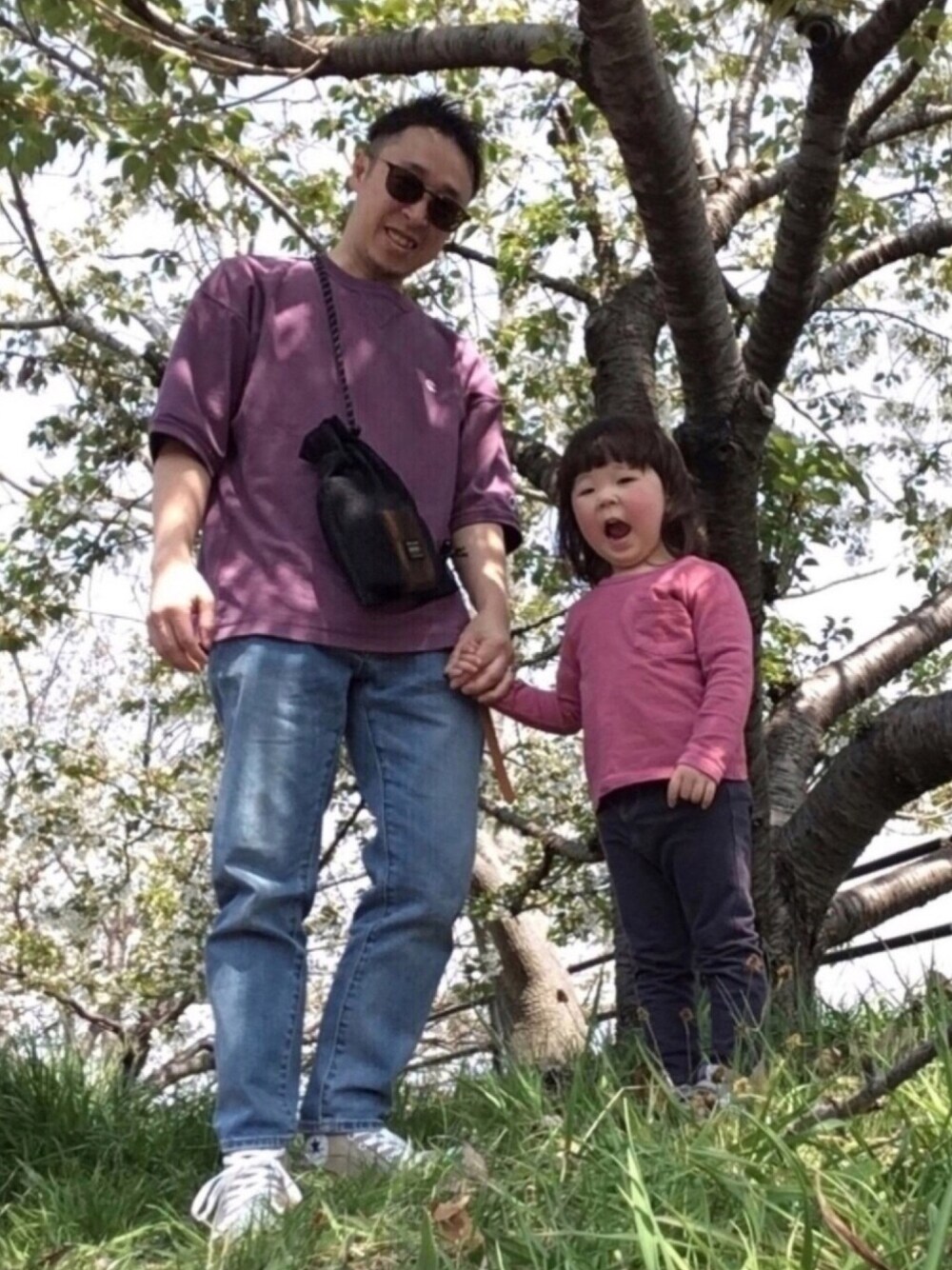 パープル系のTシャツ/カットソー、ブルー系のデニムパンツ、ベージュ系のスニーカーを着用したメンズの春コーディネートの1枚目の写真