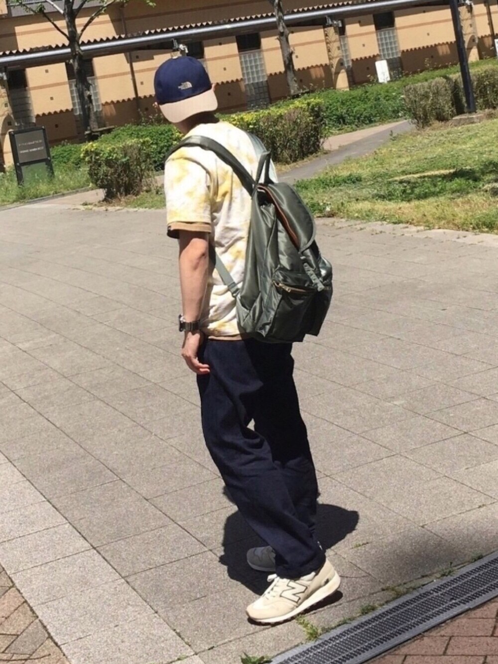 イエロー系のTシャツ/カットソー、ベージュ系のTシャツ/カットソー、ブルー系のデニムパンツを着用したメンズの春コーディネートの1枚目の写真