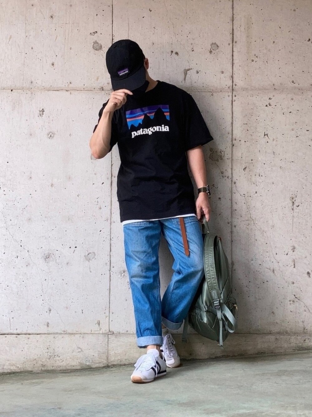 ブラック系のTシャツ/カットソー、ブルー系のデニムパンツ、グリーン系のバックパック/リュックを着用したメンズの夏コーディネートの1枚目の写真