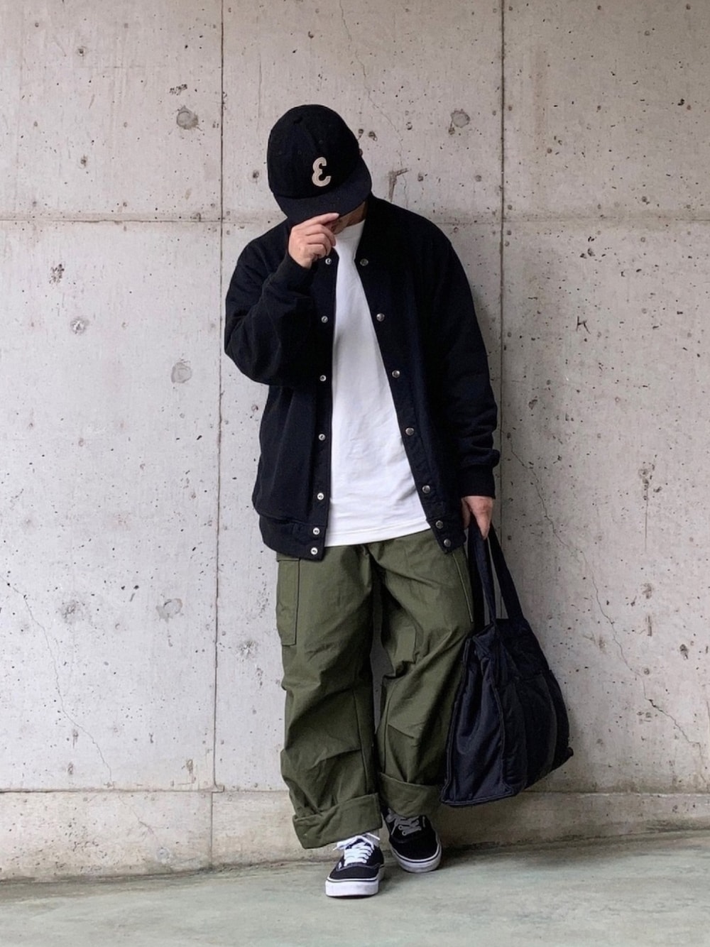ブラック系のカーディガン/ボレロ、グリーン系のカーゴパンツ、ブラック系のトートバッグを着用したメンズの秋コーディネートの1枚目の写真