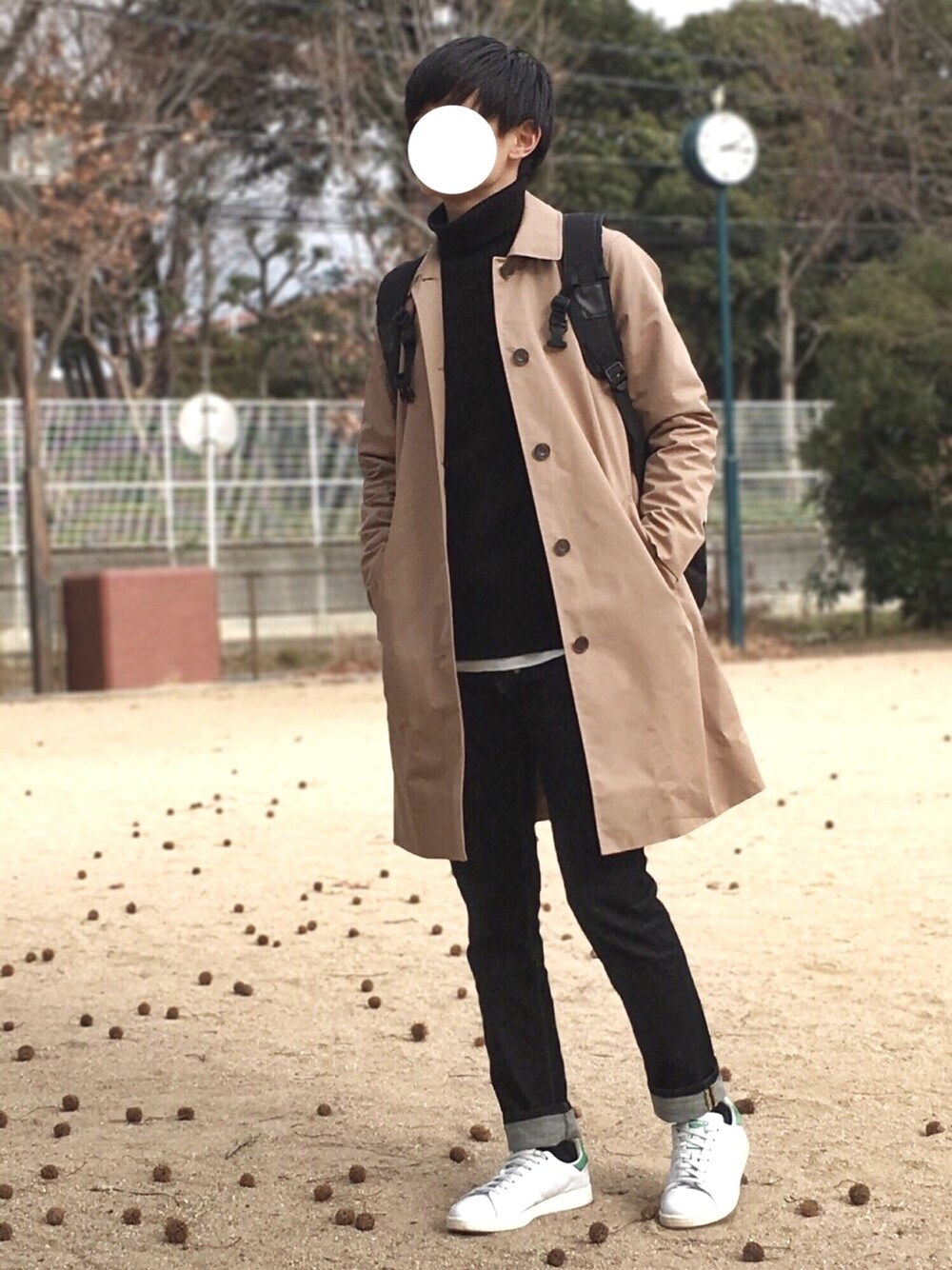 ベージュ系のステンカラーコート、ブラック系のニット/セーター、ホワイト系のTシャツ/カットソーを着用したメンズの冬コーディネートの1枚目の写真