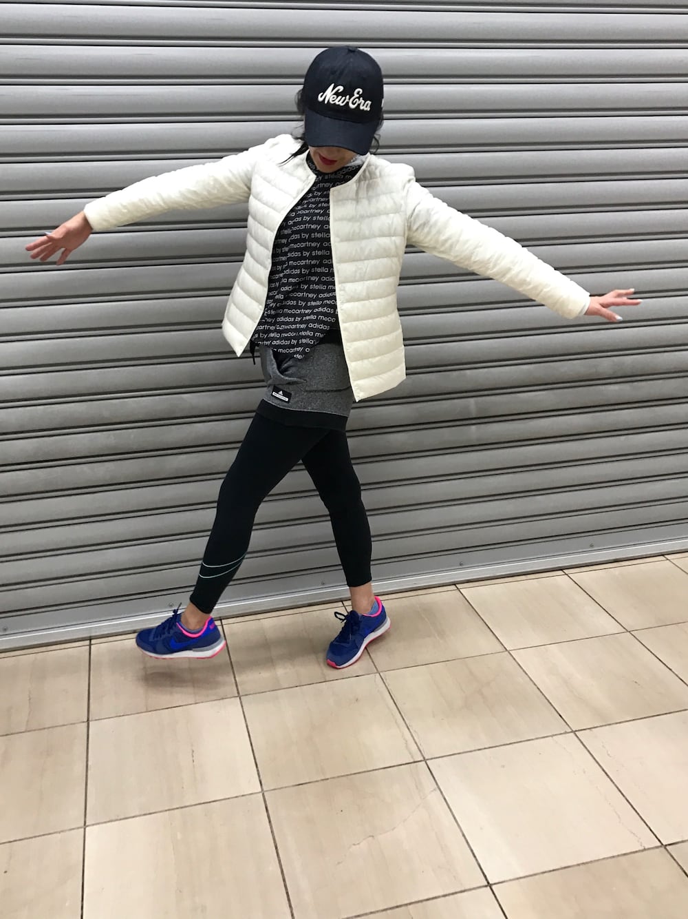 ブラック系のTシャツ/カットソー、ブラック系のTシャツ/カットソー、ホワイト系のダウンジャケット/コートを着用したレディースの春コーディネートの1枚目の写真