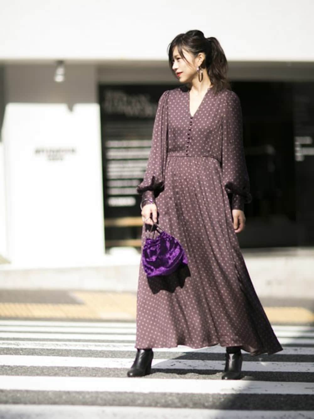 パープル系のハンドバッグ、ブラック系のブーツ、ブラウン系のワンピースを着用したレディースの秋コーディネートの1枚目の写真