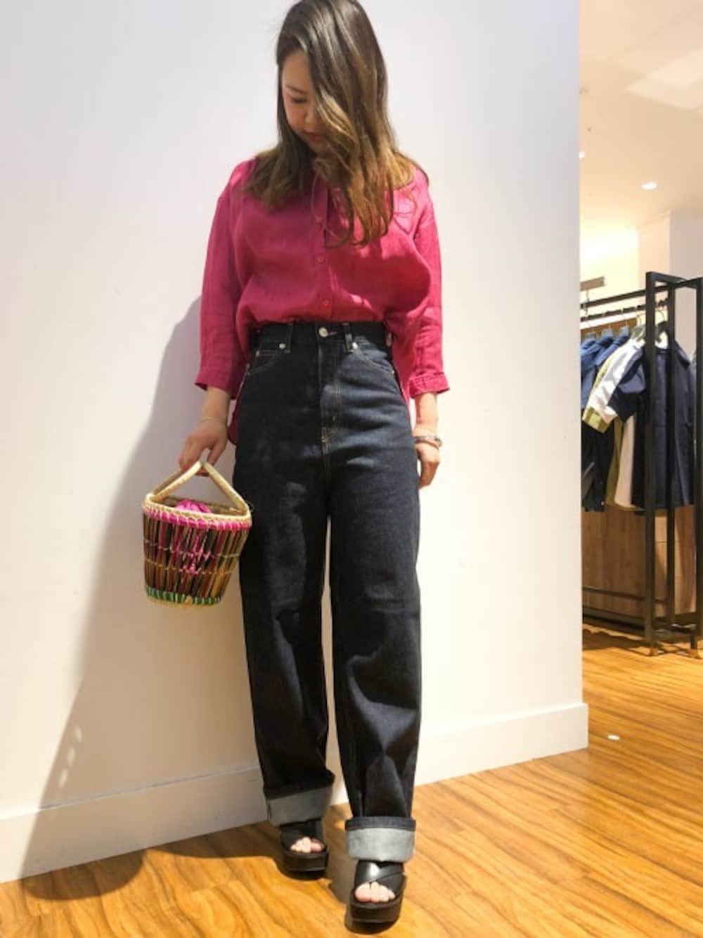 ピンク系のシャツ/ブラウス、ブルー系のデニムパンツ、グリーン系のかごバッグを着用したレディースの春コーディネートの1枚目の写真