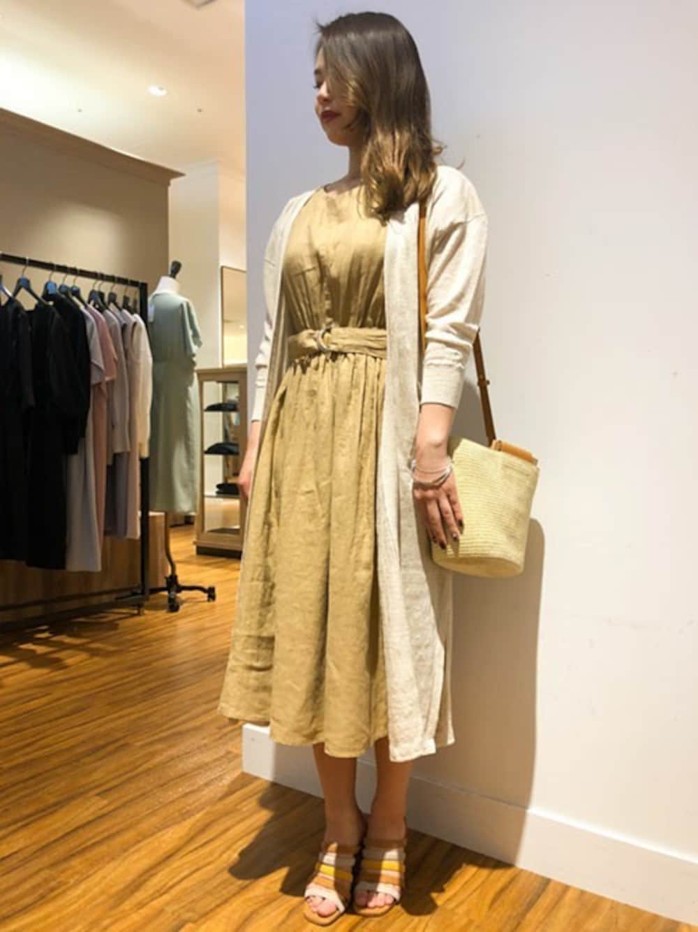 ベージュ系のワンピース、ホワイト系のカーディガン/ボレロ、ベージュ系のショルダーバッグを着用したレディースの春コーディネートの1枚目の写真