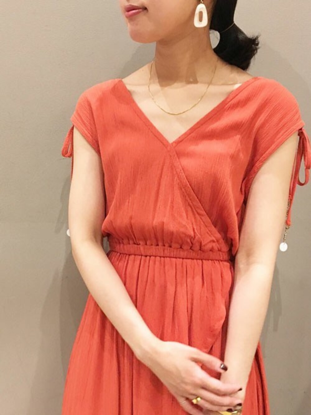 オレンジ系のワンピースを着用したレディースの夏コーディネートの1枚目の写真