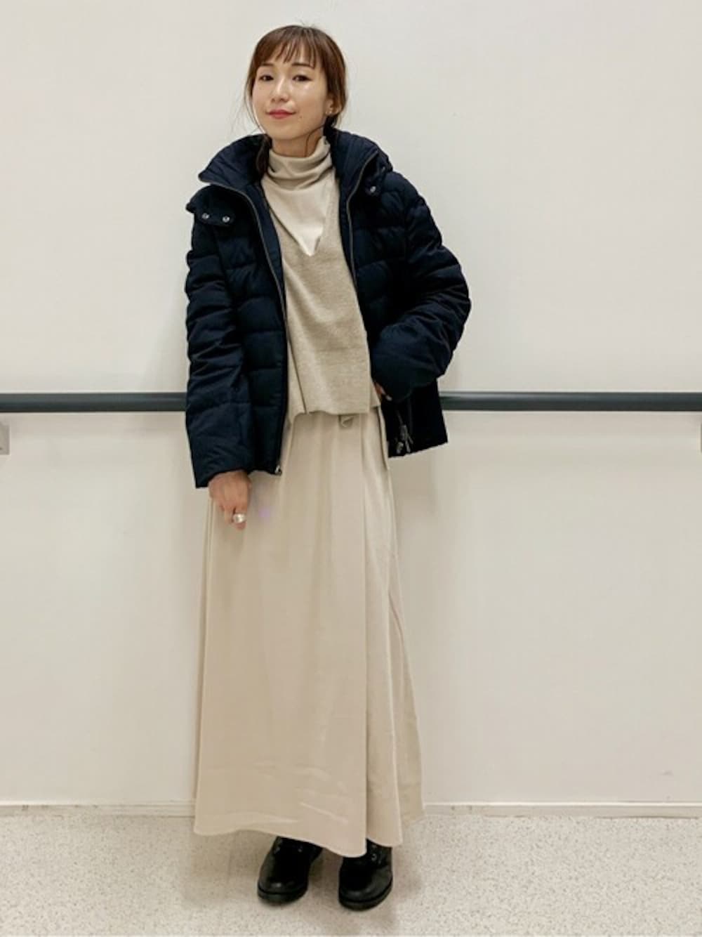 ブルー系のダウンジャケット/コート、ベージュ系のワンピースを着用したレディースの秋コーディネートの1枚目の写真