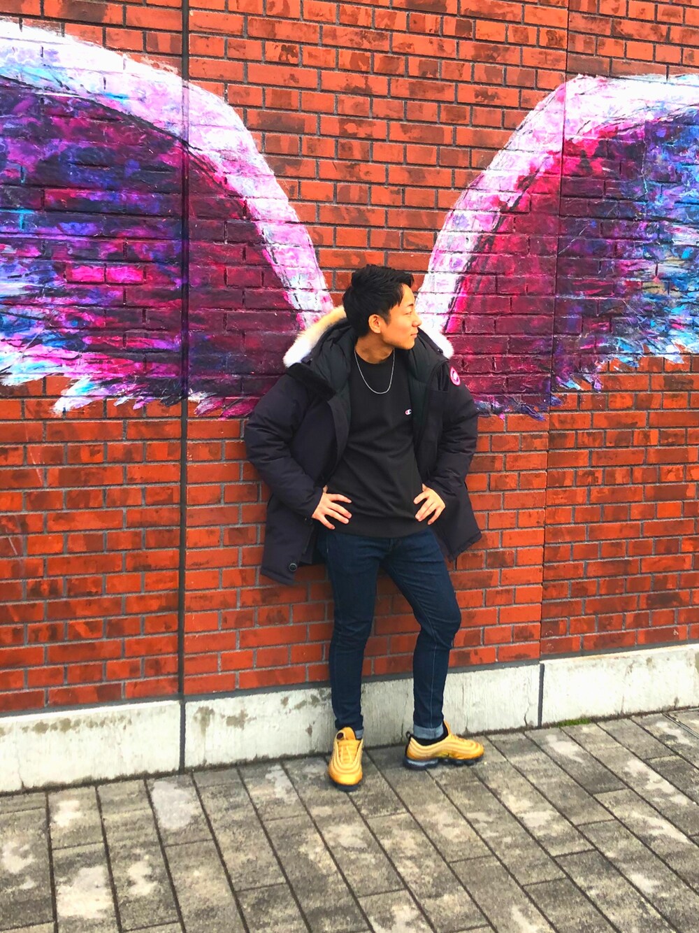 ブラック系のダウンジャケット/コート、ブラック系のスウェット、ブルー系のデニムパンツを着用したメンズの冬コーディネートの1枚目の写真