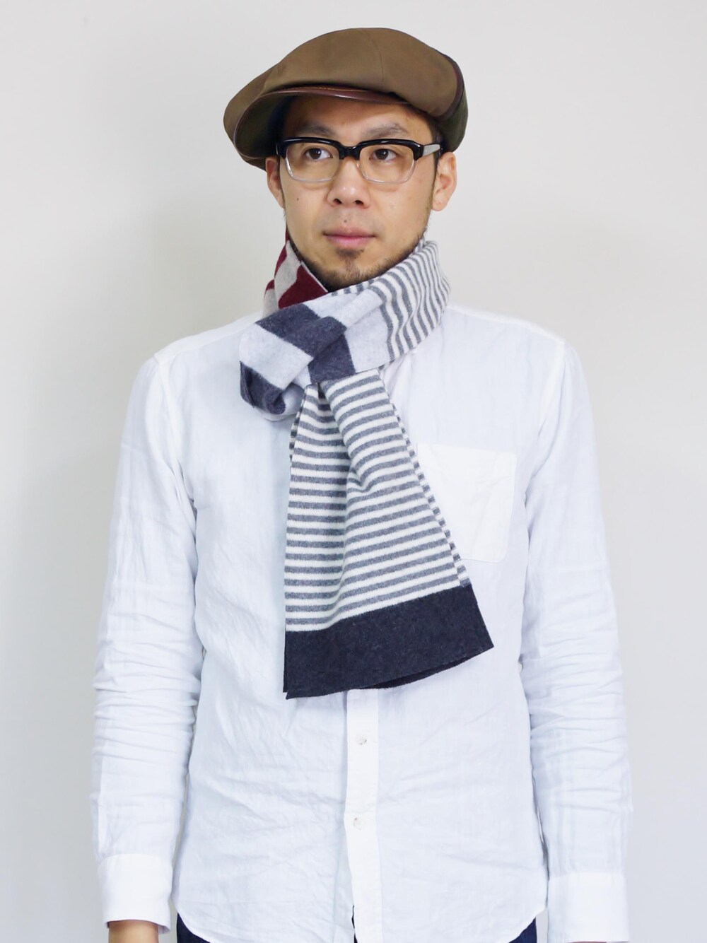 ブルー系のマフラー、グリーン系のキャスケットを着用したメンズの秋コーディネートの1枚目の写真