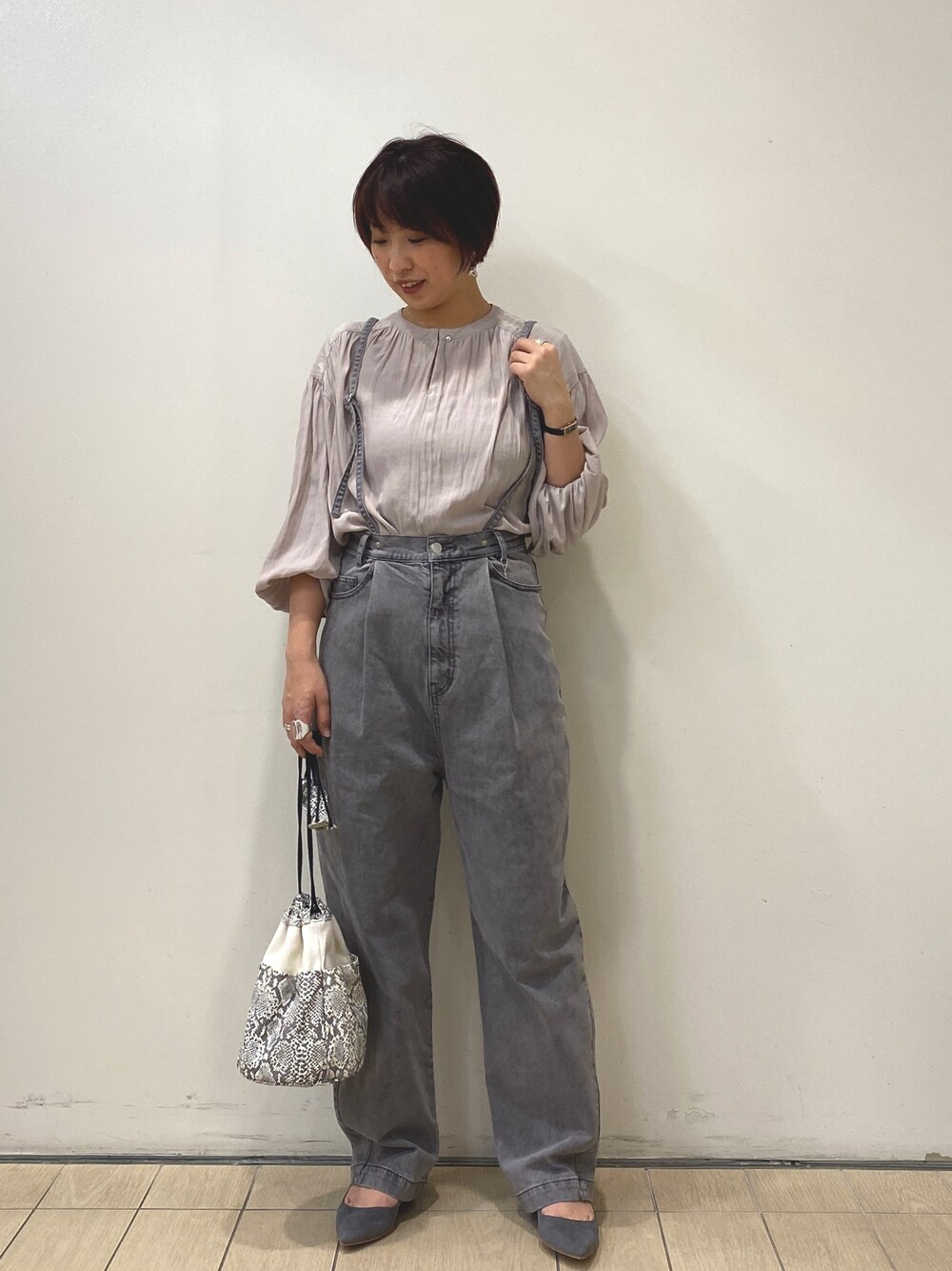 ベージュ系のシャツ/ブラウス、グレー系のデニムパンツ、ホワイト系のショルダーバッグを着用したレディースの冬コーディネートの1枚目の写真