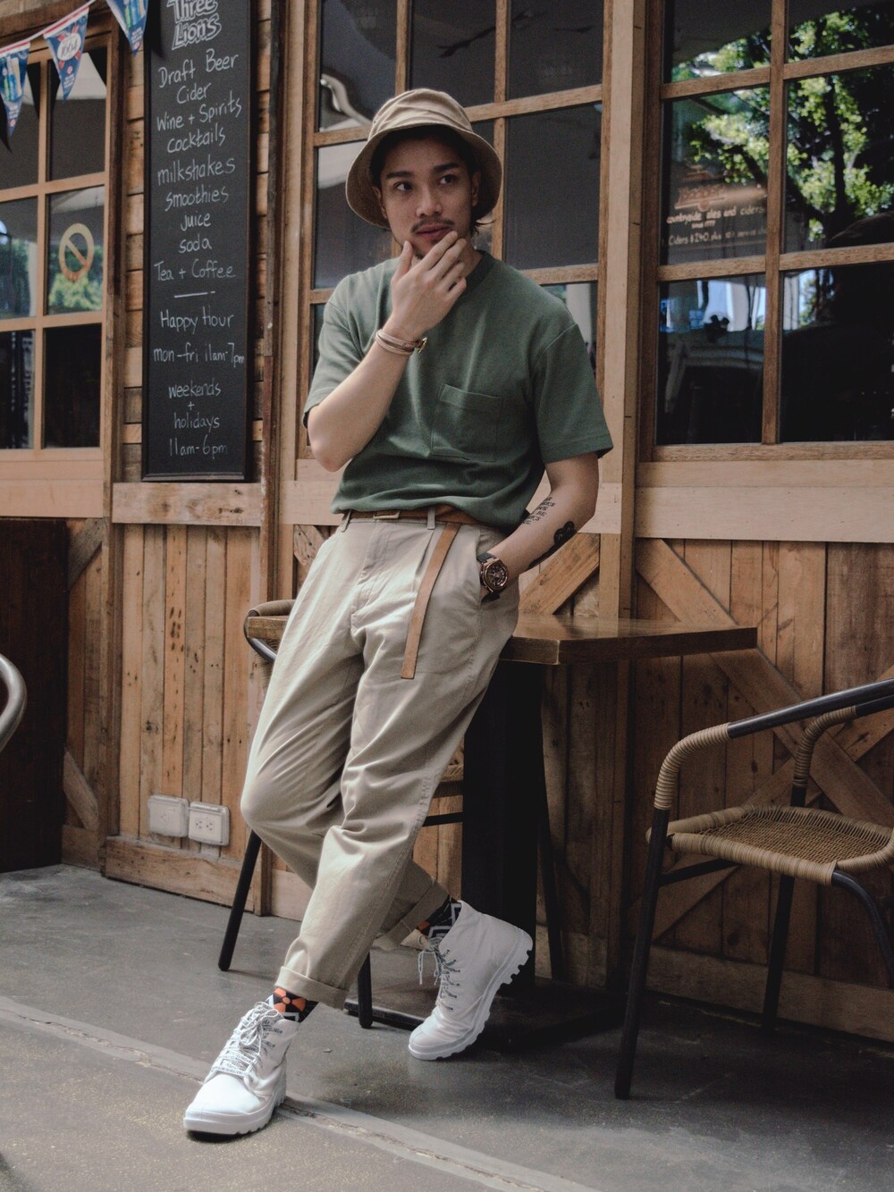 グリーン系のTシャツ/カットソー、ベージュ系のスラックス、ホワイト系のスニーカーを着用したメンズの秋コーディネートの1枚目の写真