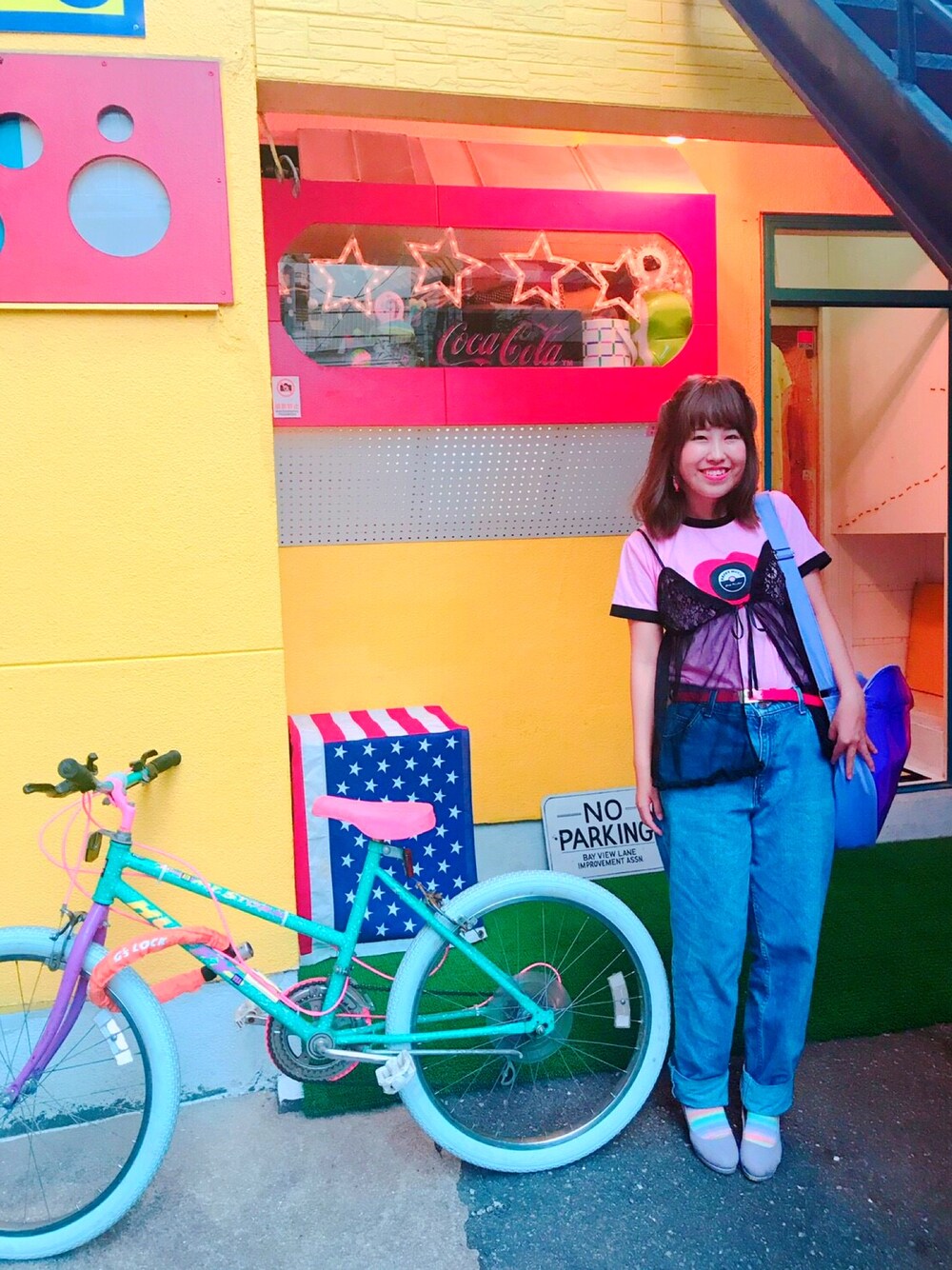 ブラック系のキャミソール、ピンク系のTシャツ/カットソー、ブルー系のデニムパンツを着用したレディースの春コーディネートの1枚目の写真