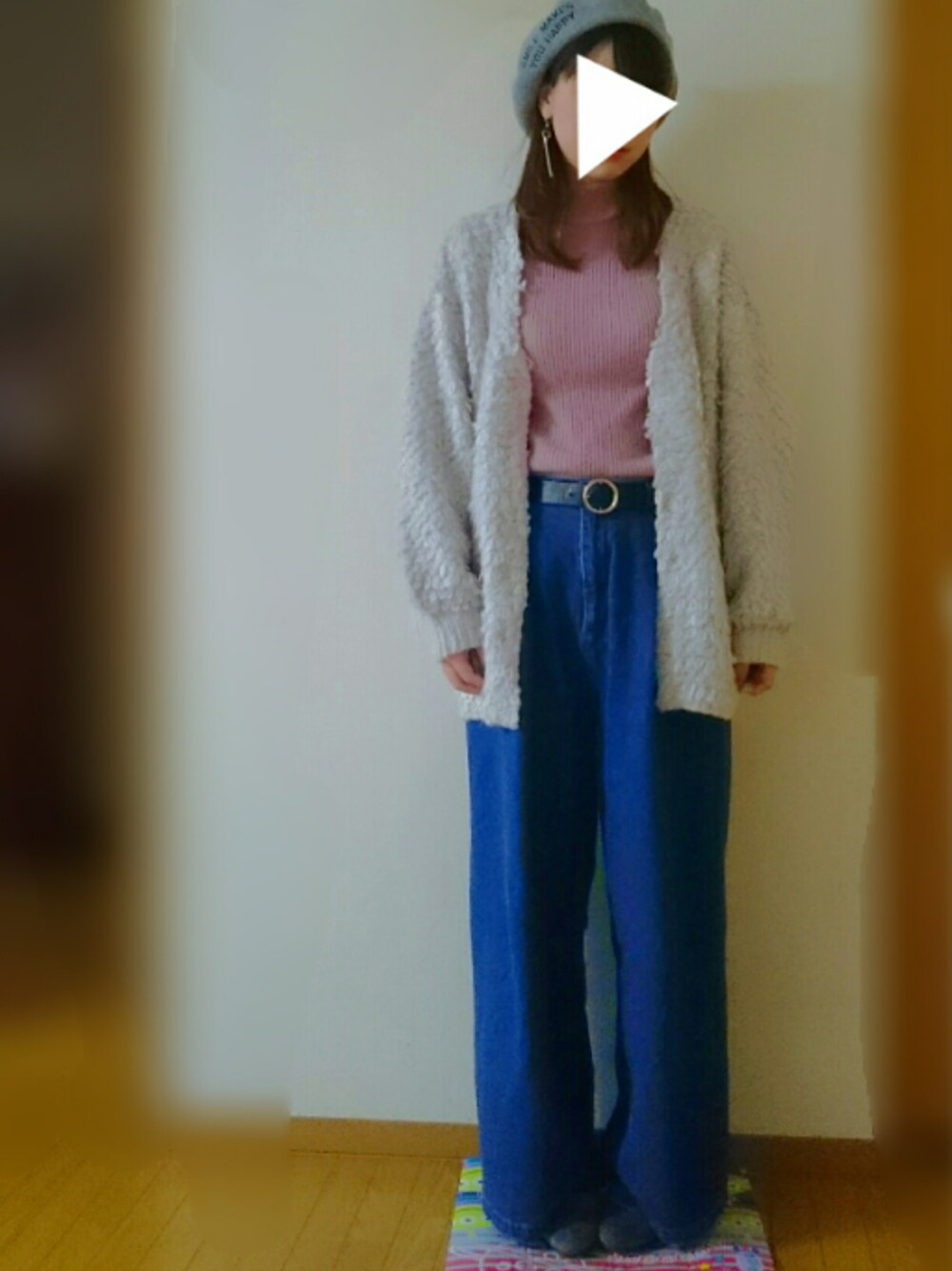 ブルー系のデニムパンツ、グレー系のカーディガン/ボレロ、ピンク系のニット/セーターを着用したレディースの冬コーディネートの1枚目の写真