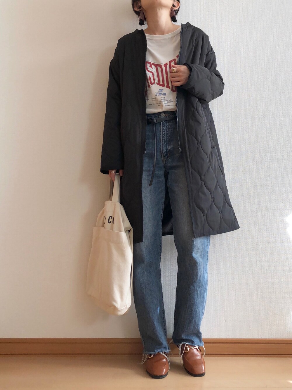 ブラック系のノーカラージャケット、ホワイト系のTシャツ/カットソー、ブルー系のデニムパンツを着用したレディースの秋コーディネートの1枚目の写真