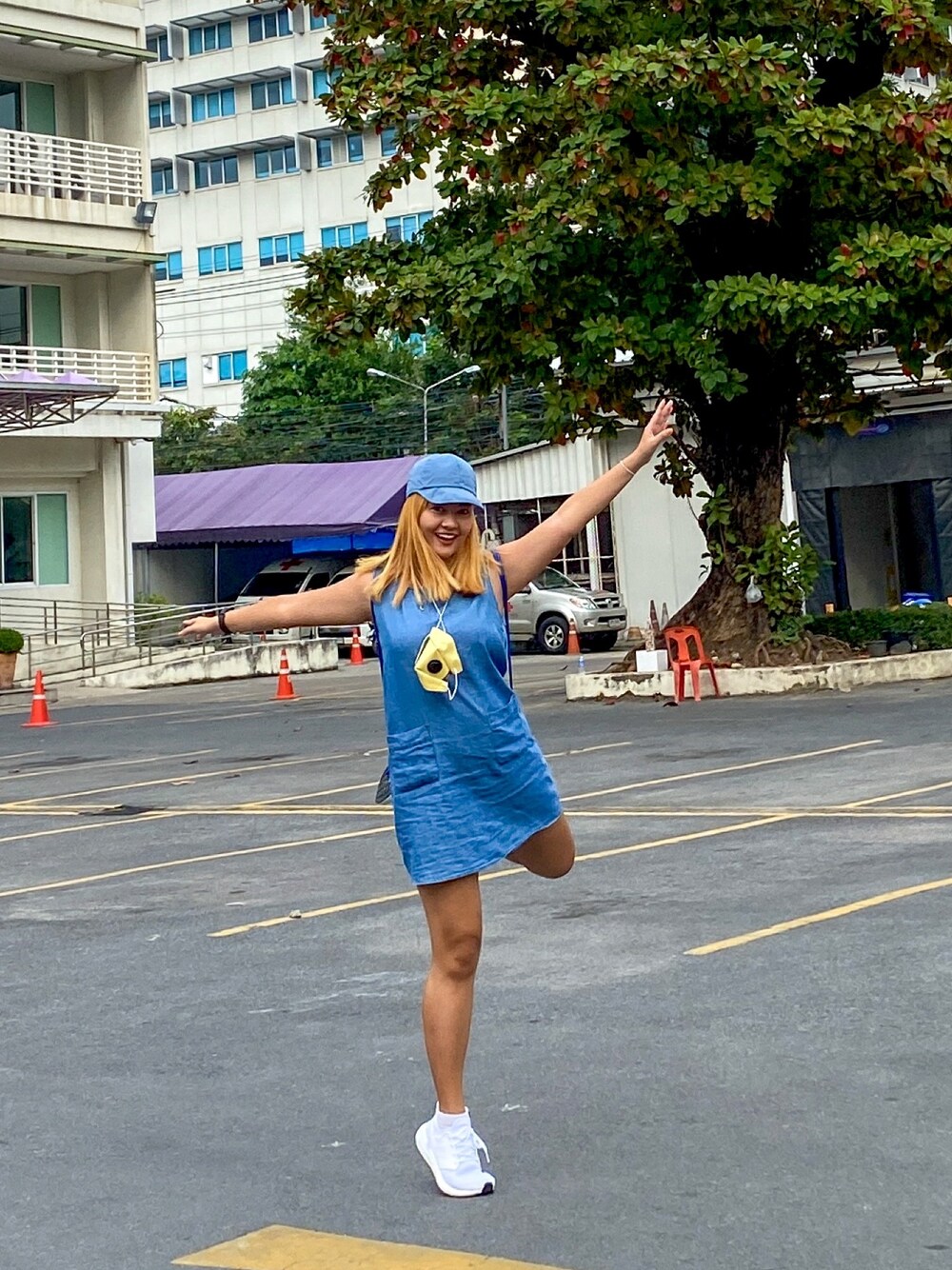 ブルー系のワンピース、ホワイト系のスニーカー、イエロー系のマスクを着用したレディースの秋コーディネートの1枚目の写真