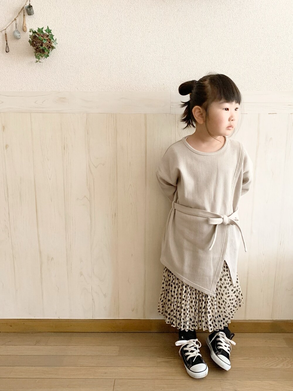 グレー系のTシャツ/カットソー、ベージュ系のスカート、ブラック系のスニーカーを着用したキッズの春コーディネートの1枚目の写真