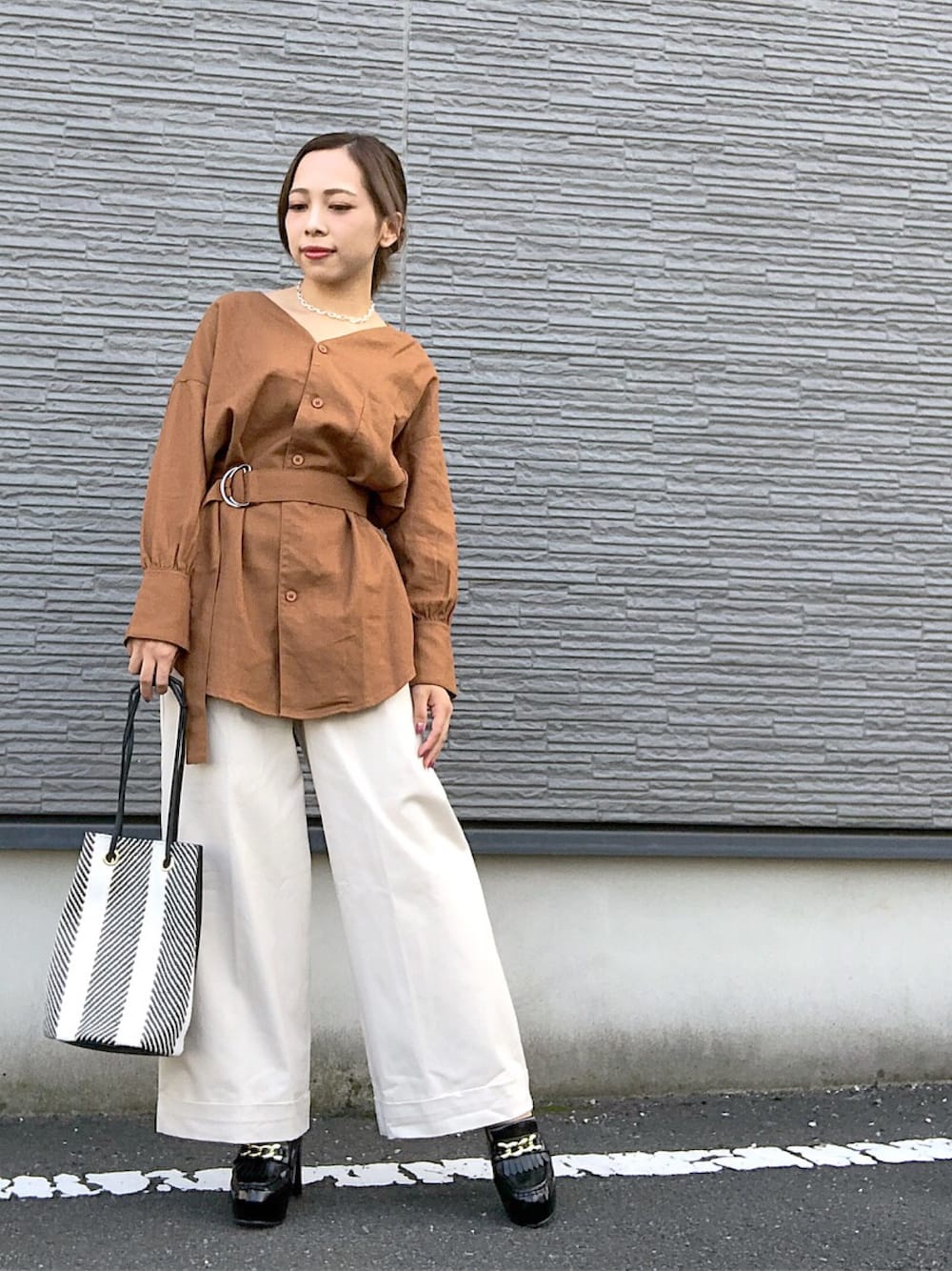 ブラウン系のシャツ/ブラウス、ホワイト系のその他パンツ、ブラック系のショルダーバッグを着用したレディースの秋コーディネートの1枚目の写真