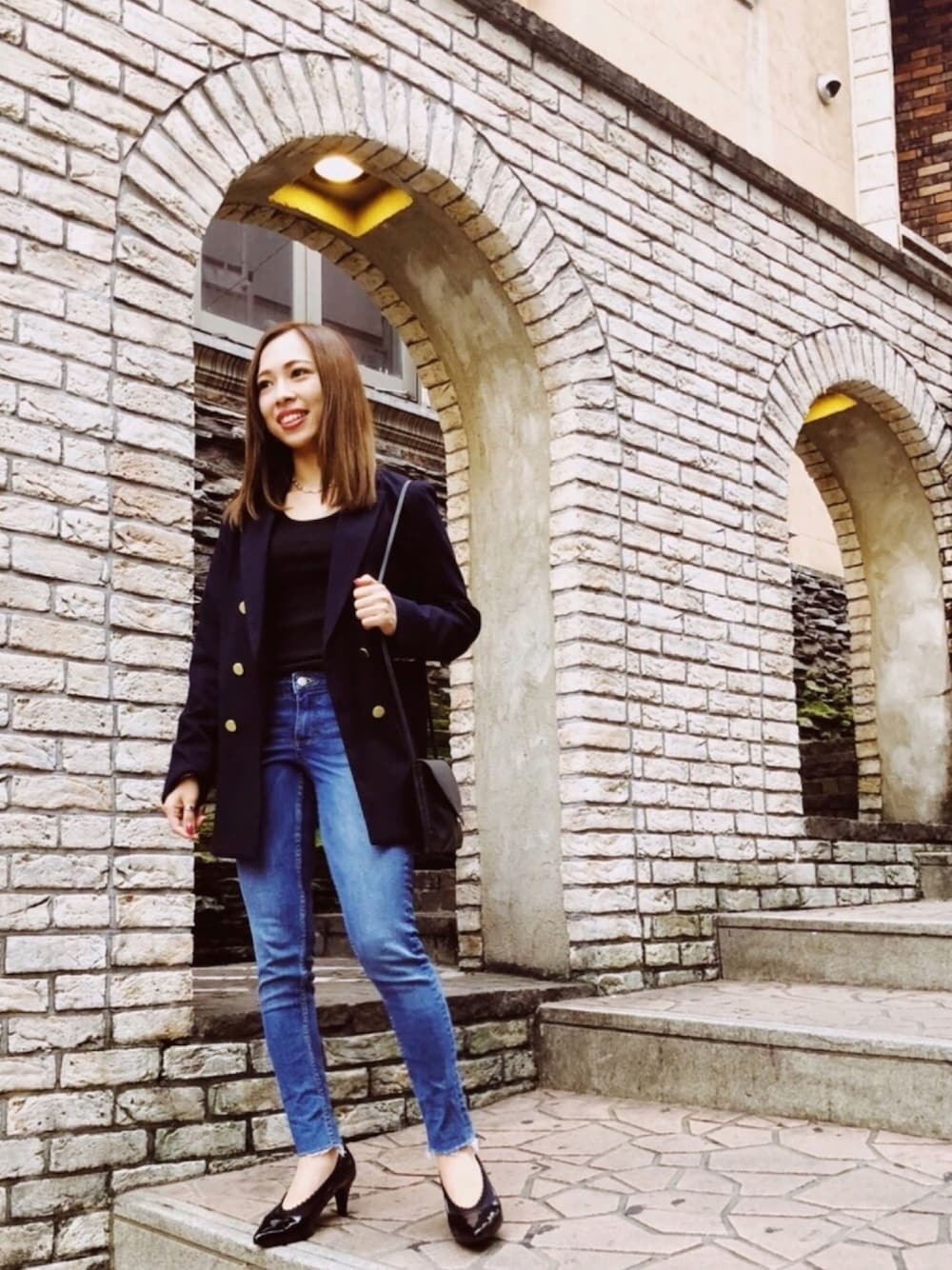 ブルー系のテーラードジャケット、ブルー系のデニムパンツ、ブラック系のパンプスを着用したレディースの秋コーディネートの1枚目の写真