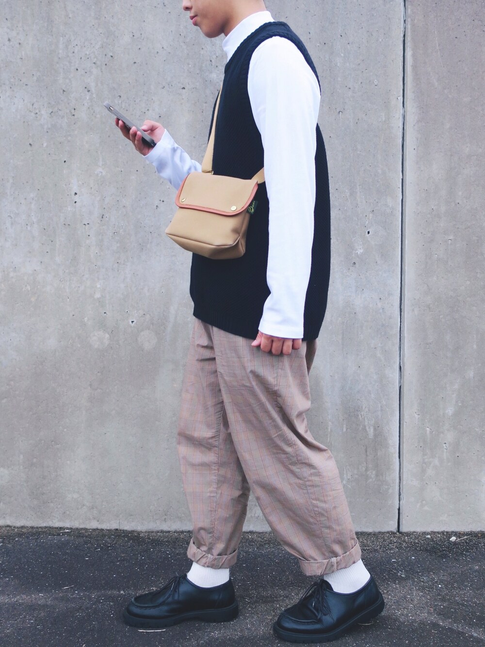 ホワイト系のTシャツ/カットソー、ブラック系のベスト、ベージュ系のその他パンツを着用したメンズの秋コーディネートの1枚目の写真
