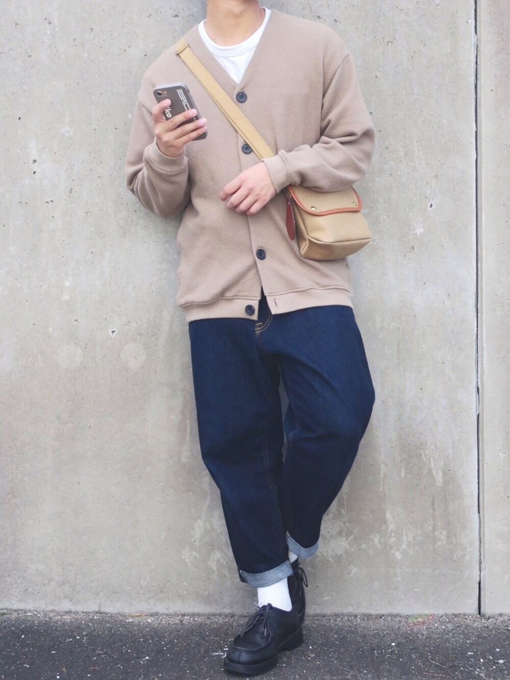 ベージュ系のカーディガン/ボレロ、ホワイト系のTシャツ/カットソー、ブルー系のデニムパンツを着用したメンズの秋コーディネートの1枚目の写真