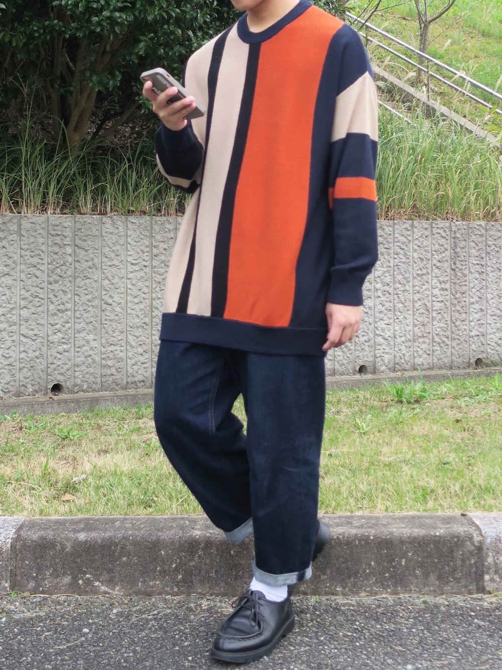 ベージュ系のニット/セーター、ブルー系のデニムパンツ、ブラック系のその他シューズを着用したメンズの秋コーディネートの1枚目の写真