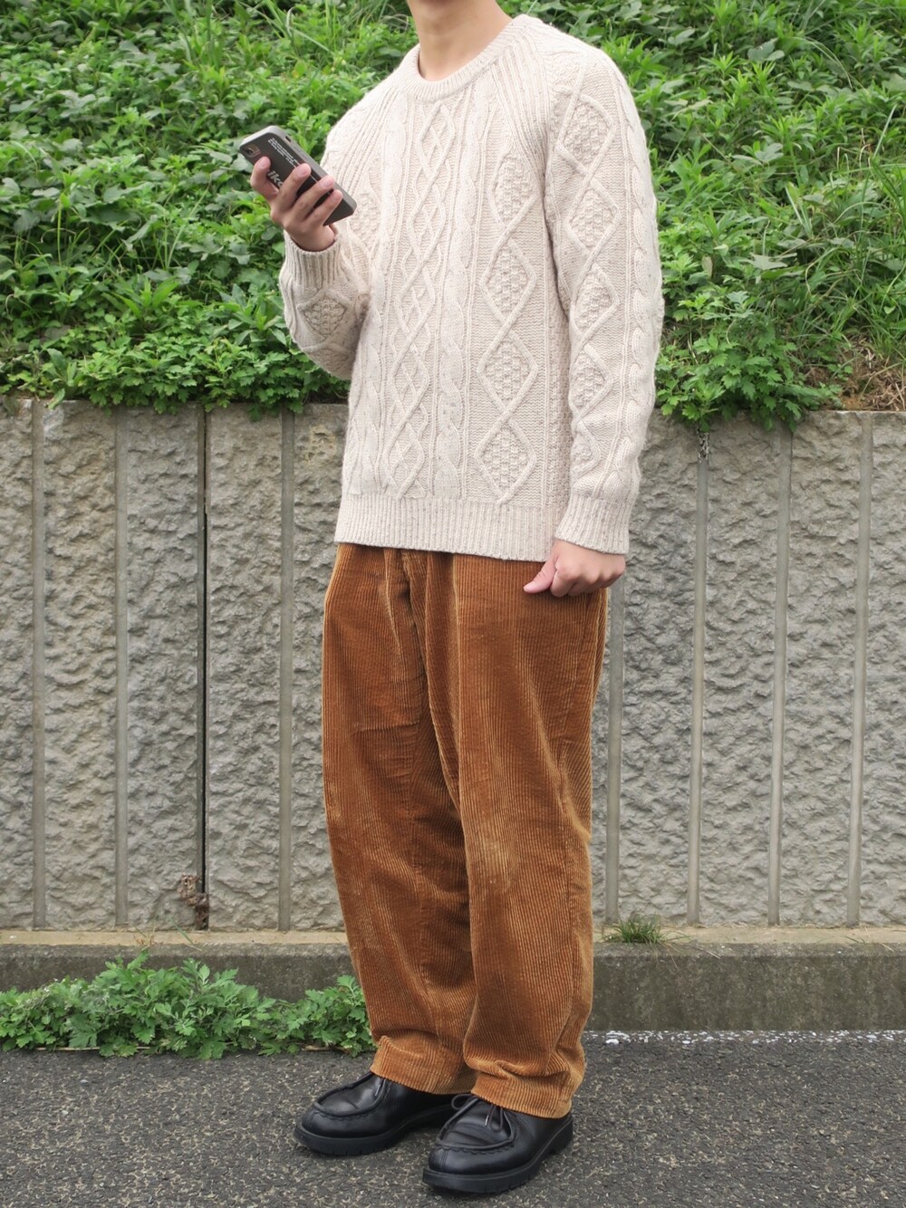 ベージュ系のニット/セーター、イエロー系のその他パンツ、ブラック系のその他シューズを着用したメンズの秋コーディネートの1枚目の写真