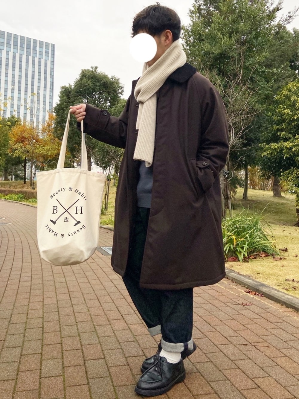 「ステンカラーコート、Steven Alan、ニット、マフラー、URBAN RESEARCH DOORS、テーパードデニム、UNIQLO、革靴、KLEMAN、トートバッグ」｜「URBAN RESEARCH DOORSの【BEGIN  1月号掲載】ハミルトンウール クルーネックプルオーバー（ニット/セーター、ブルー系）」を使った、ぜっきーさん（メンズ・165cm）の冬コーディネートの1枚目の写真
