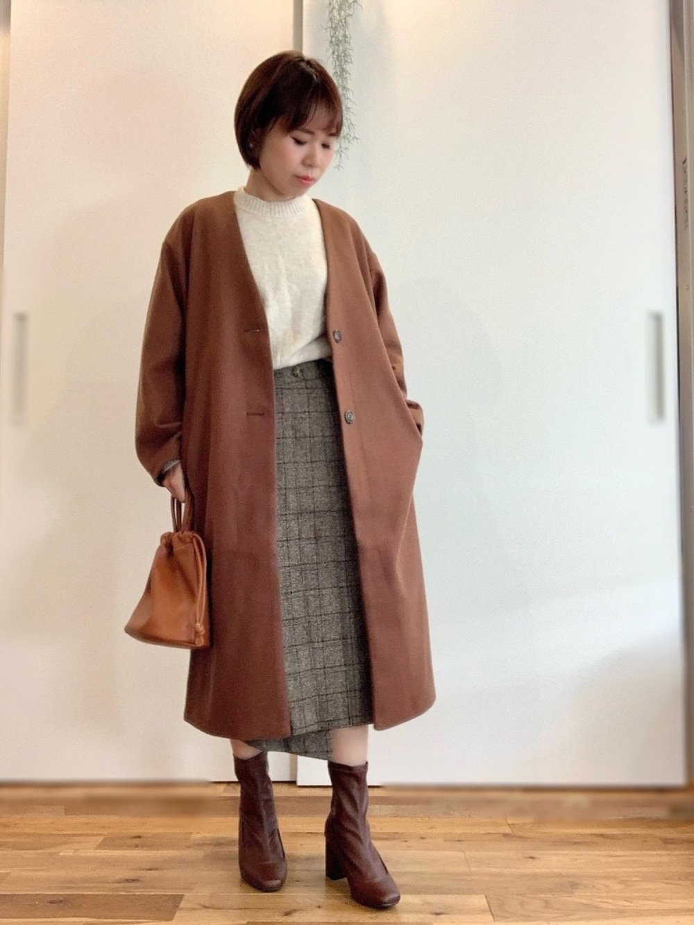 ベージュ系のニット/セーター、ブラウン系のノーカラーコート、その他のスカートを着用したレディースの冬コーディネートの1枚目の写真
