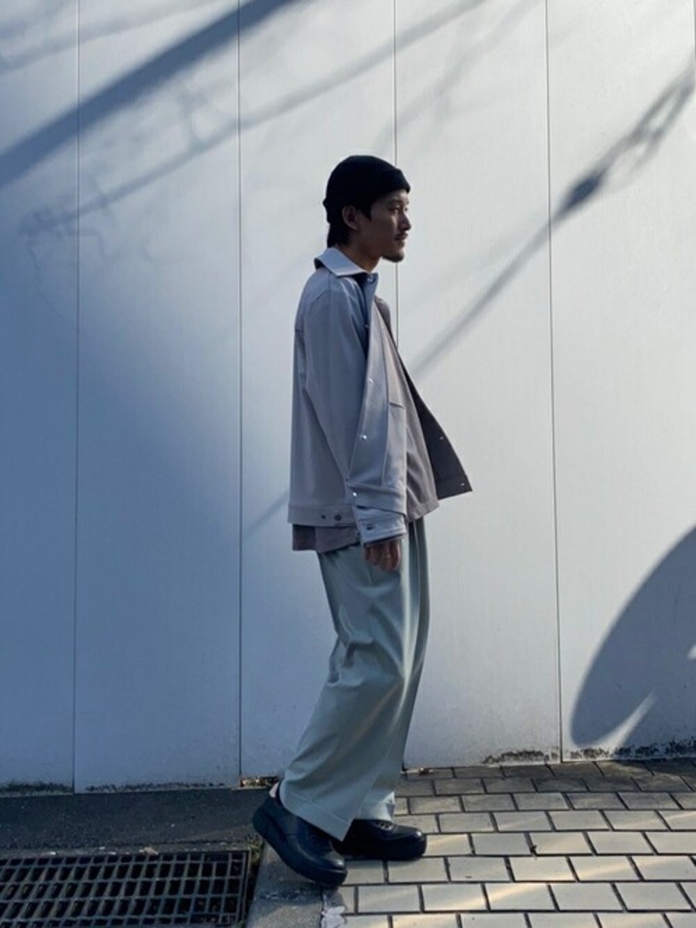 グレー系のブルゾン、グリーン系のスラックスを着用したメンズの春コーディネートの1枚目の写真