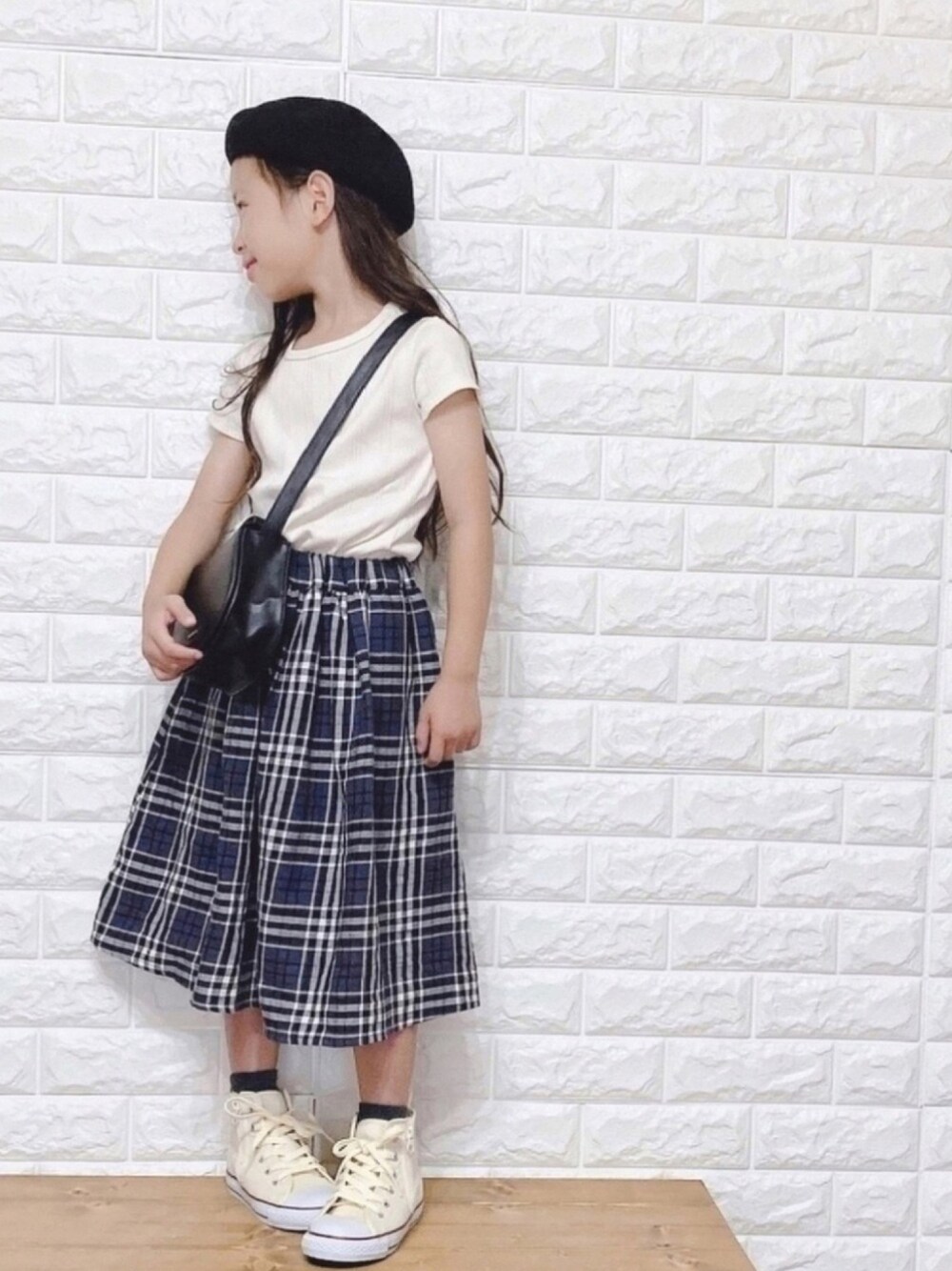 ホワイト系のTシャツ/カットソー、ブラック系のスカート、ホワイト系のスニーカーを着用したキッズの夏コーディネートの1枚目の写真