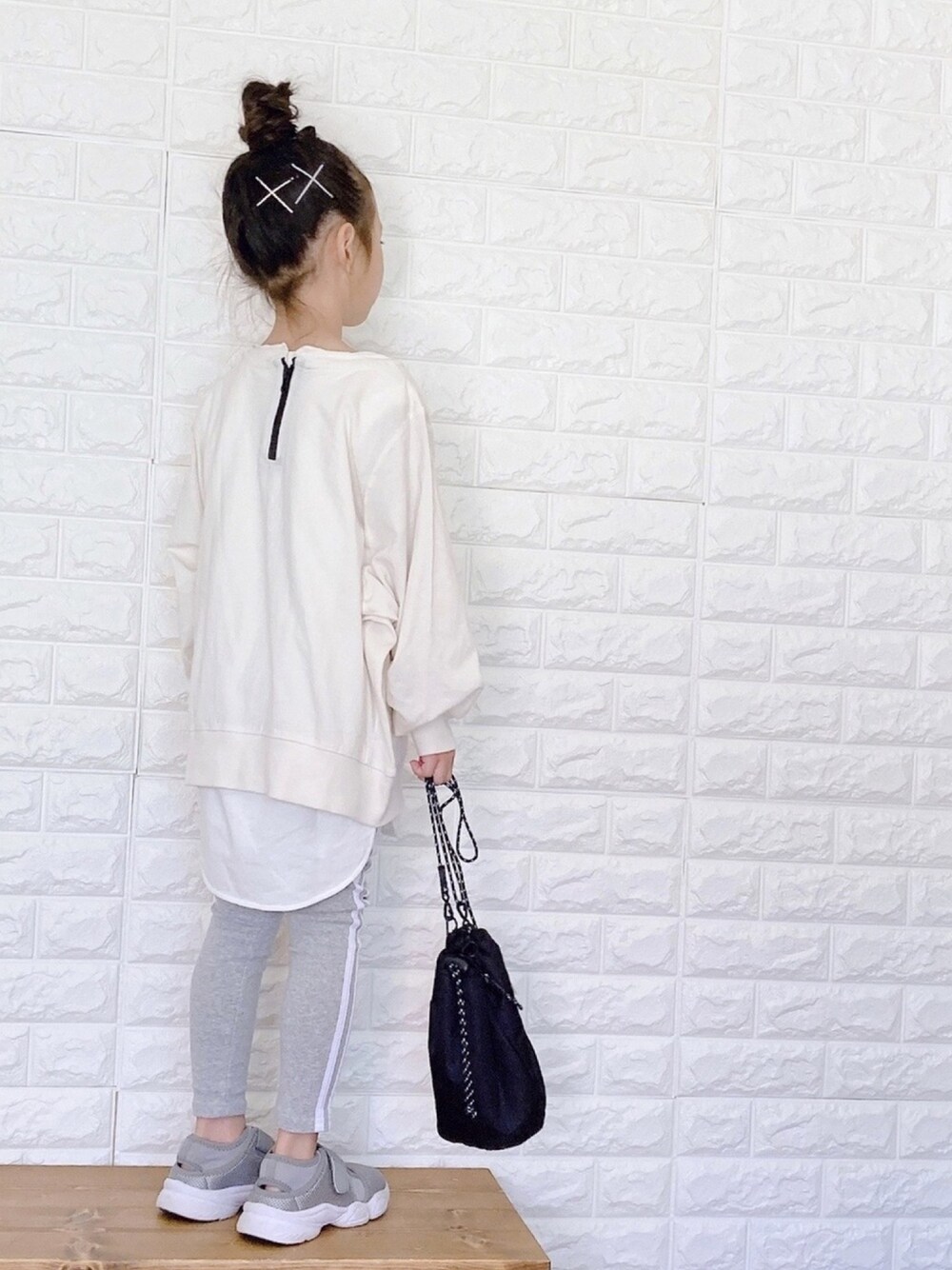 「ラインパンツ、ラインレギンス、レイヤードスタイル、秋服準備はじめました、巾着バッグ、サンダル、お団子ヘアー、オーバーサイズ」｜「antiquaのぽわっと袖がかわいくて。バルーンスリーブトップス（Tシャツ/カットソー、ホワイト系）」を使った、uranさん（キッズ・110cm）の秋コーディネートの1枚目の写真