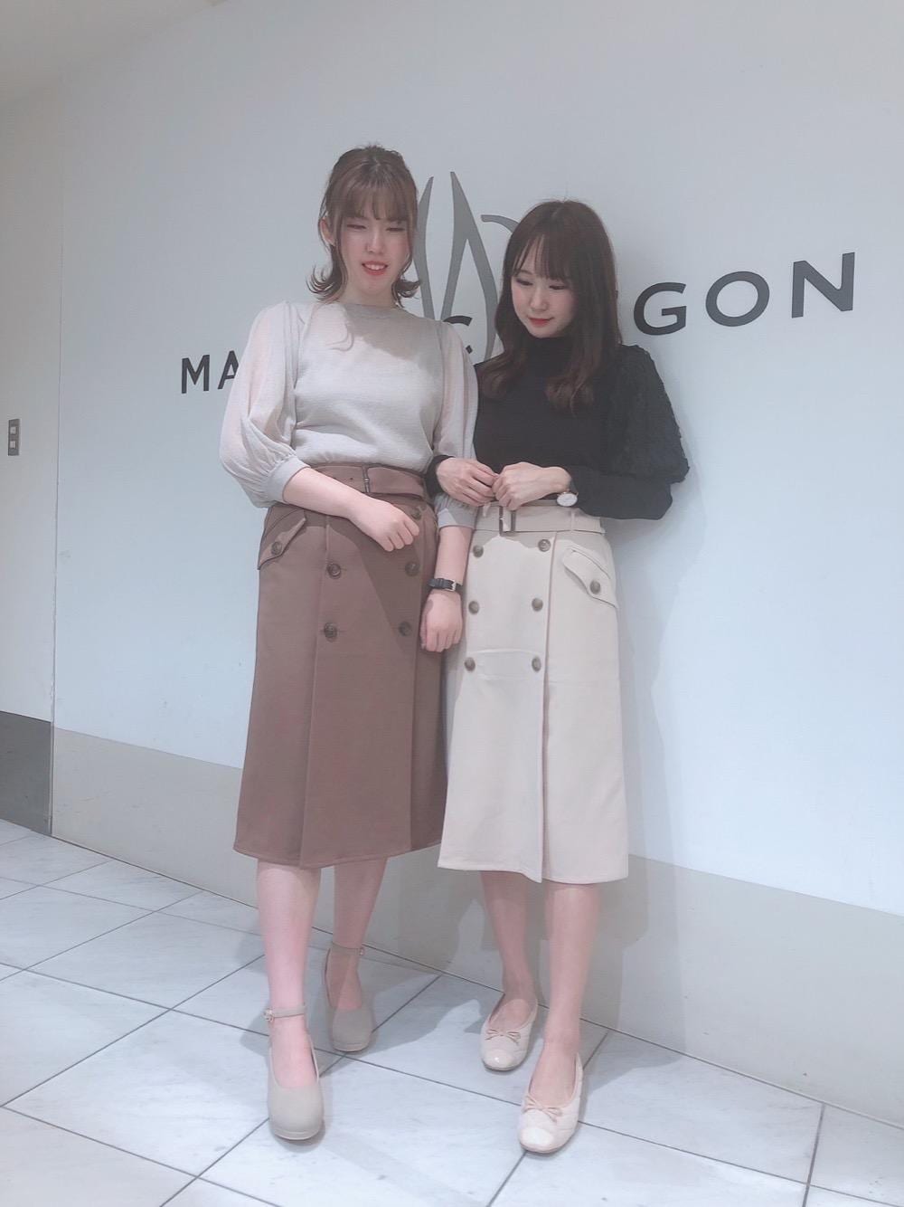 ベージュ系のパンプス、ホワイト系のスカート、ブラウン系のスカートを着用したレディースの秋コーディネートの1枚目の写真