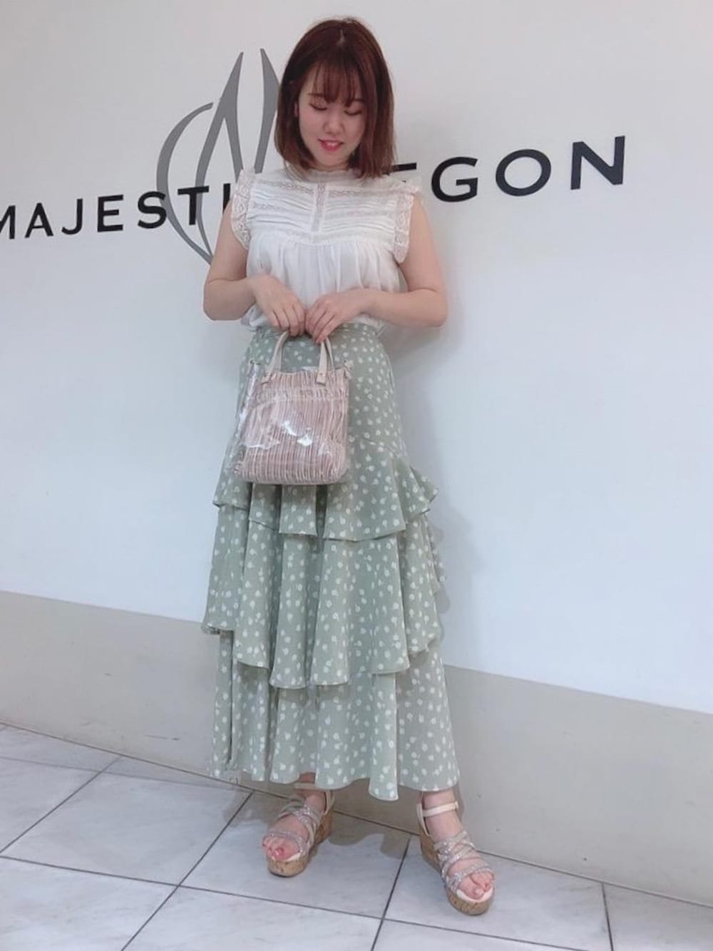 ホワイト系のサンダル、ホワイト系のハンドバッグ、ホワイト系のタンクトップを着用したレディースの夏コーディネートの1枚目の写真