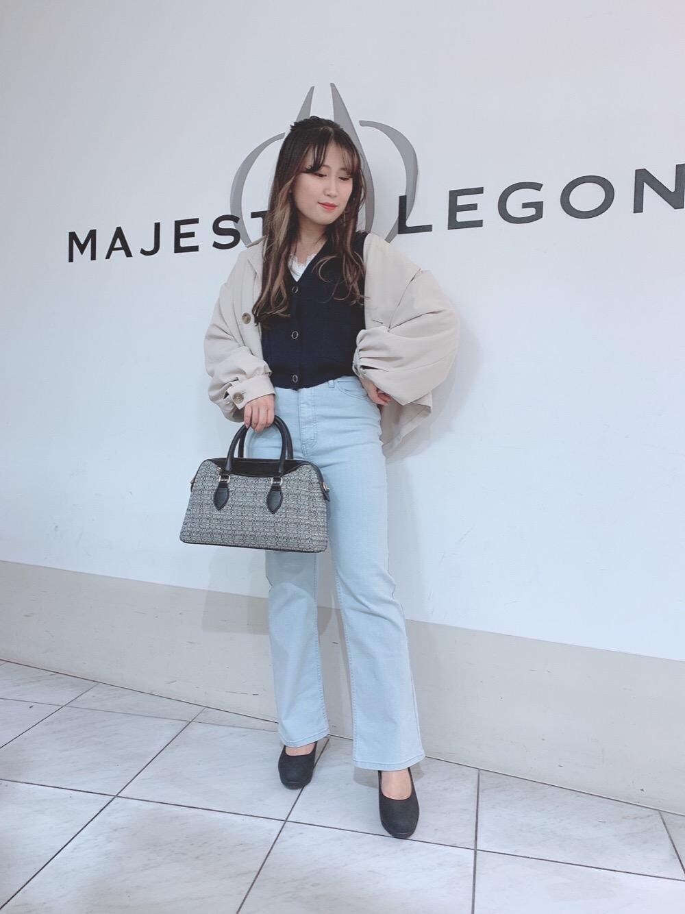 ブルー系のデニムパンツ、ベージュ系のトレンチコート、ブラック系のパンプスを着用したレディースの冬コーディネートの1枚目の写真