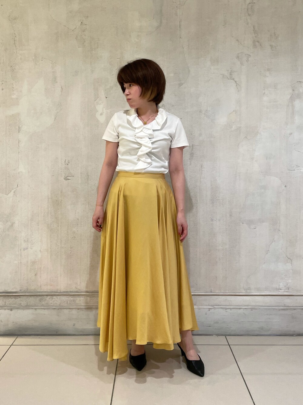 ホワイト系のTシャツ/カットソー、イエロー系のスカートを着用したレディースの春コーディネートの1枚目の写真