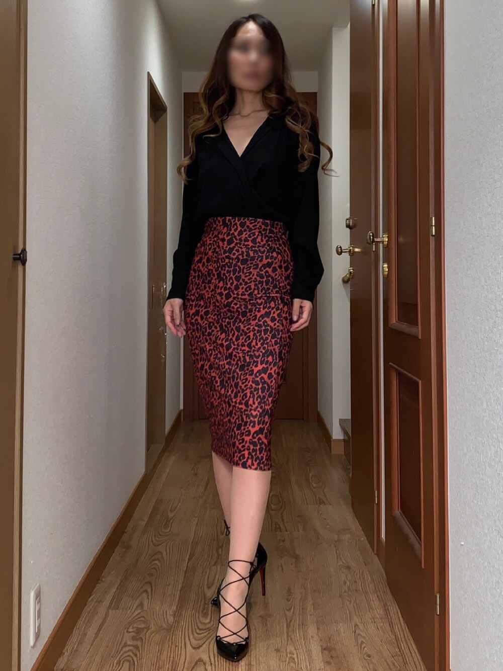 ブラック系のパンプス、オレンジ系のスカート、ブラック系のシャツ/ブラウスを着用したレディースの夏コーディネートの1枚目の写真